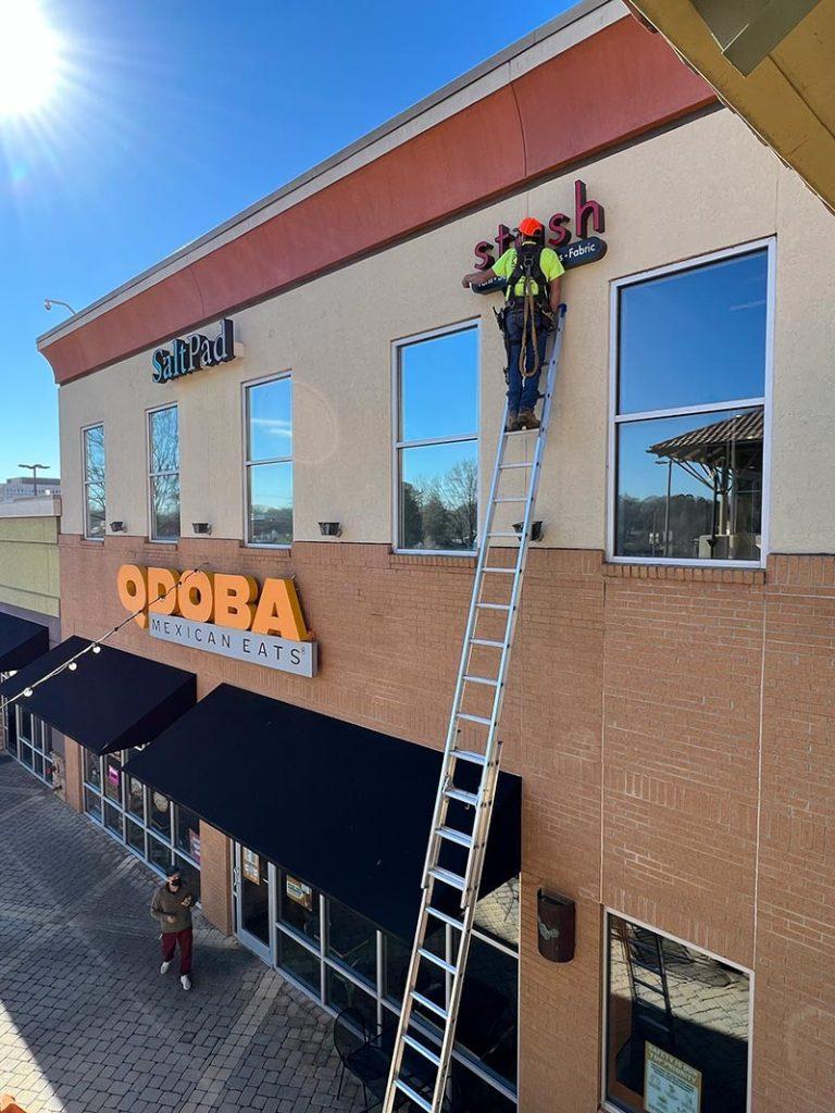 Business sign installation on a commercial storefront Business sign installation on a commercial storefront